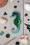 Assembli Paper Seahorse craft made from Caribbean green metallic paper, showcasing a detailed seahorse design.