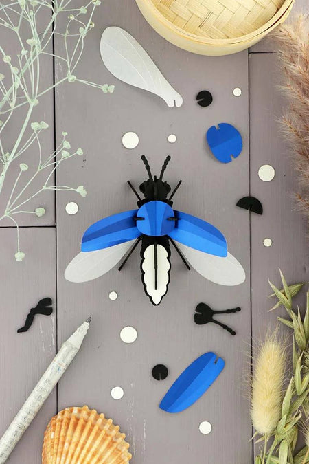 Emerald green metallic paper firefly craft by Assembli made from colorful, shiny paper for creative arts and crafts projects.