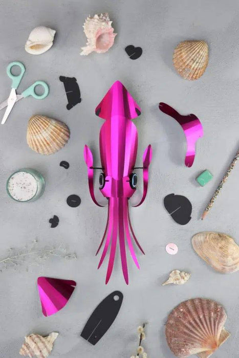 Pink paper craft squid made by Assembli, featuring detailed paper fins and a whimsical design for creative craft projects.