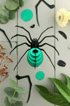 Red paper spider craft by Assembli featuring detailed paper legs and body, suitable for creative arts projects.