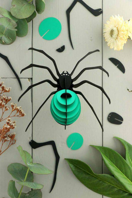 Red paper spider craft by Assembli featuring detailed paper legs and body, suitable for creative arts projects.