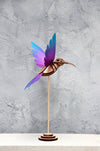 Colorful yellow and blue paper colibri craft made from textured paper by Assembli, perfect for creative paper art projects.