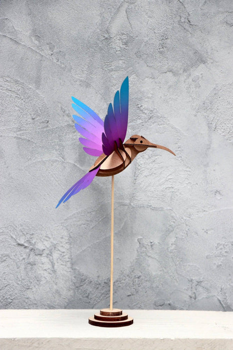 Colorful yellow and blue paper colibri craft made from textured paper by Assembli, perfect for creative paper art projects.