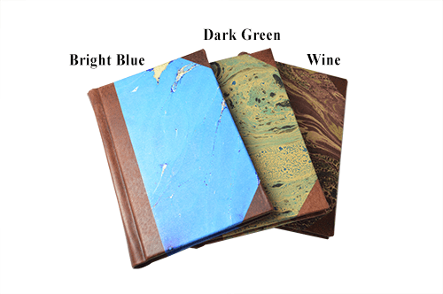 Small leather journal with marbled paper pages, dark green handcrafted cover, and old world spine design by Il Cartiglio.