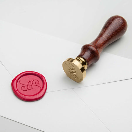 Round custom wax seal featuring intricate design, made by Papier Plume, used for sealing envelopes and adding a personal touch.