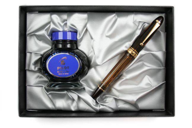 Pilot Custom 823 Smoke fountain pen with gold accents and translucent gray barrel, showcasing a luxurious writing instrument.