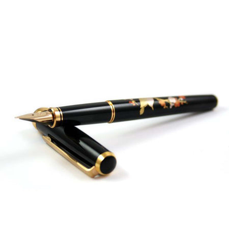 Platinum Maki-e Brush Warbler fountain calligraphy pen with fine nib, featuring detailed brush warbler design on gold-colored body.