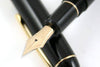 Platinum #3776 Century Black fountain pen with gold accents and fine nib, showcasing its sleek black lacquer finish.