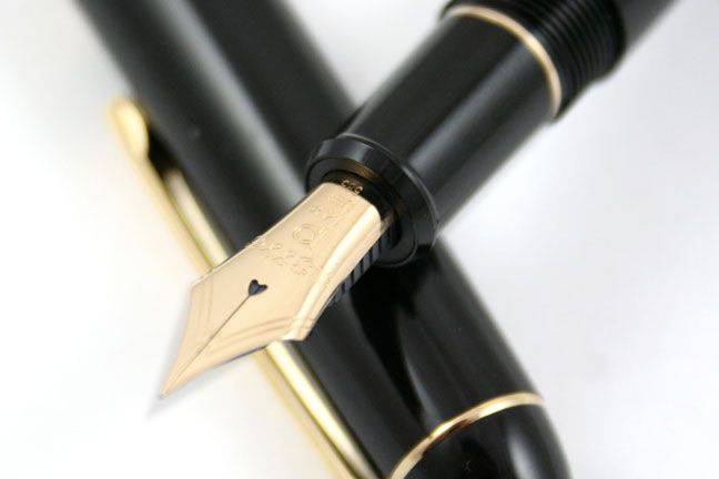 Platinum #3776 Century Black fountain pen with gold accents and fine nib, showcasing its sleek black lacquer finish.