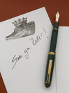 Platinum #3776 Century fountain pen with jade green celluloid barrel and fine nib, showcasing elegant design and craftsmanship.