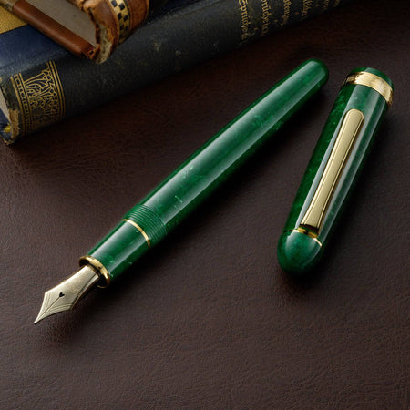 Platinum #3776 Century fountain pen with jade green celluloid body and fine nib, showcasing elegant craftsmanship.