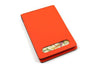 San Lorenzo regenerated leather memo pad cover in orange with sleek, stylish design and secure closure.