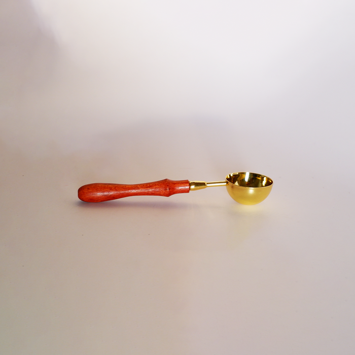 Small gold Papier Plume wax melting spoon with a smooth handle and rounded bowl for easy wax application.