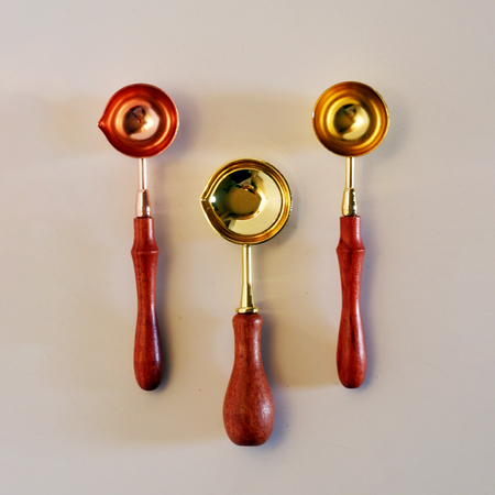 Close-up of Papier Plume wax melting spoon, showing its smooth metal surface and ergonomic handle for wax warmers.