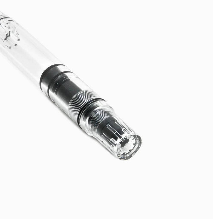 Twsbi Eco Clear fountain pen with transparent body and extra-fine steel nib, showcasing its sleek design and ink filling mechanism.