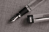 Twsbi Diamond 580AL R black fountain pen with gold accents and fine nib, showcasing its sleek design and smooth ink flow.