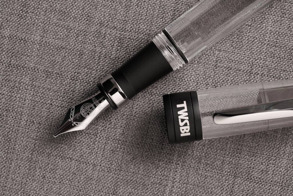 Twsbi Diamond 580AL R black fountain pen with gold accents and fine nib, showcasing its sleek design and smooth ink flow.