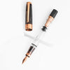 Twsbi Diamond 580 Smoke Rose Gold II fountain pen with an elegant rose gold finish and fine nib, showcasing a luxurious writing instrument.