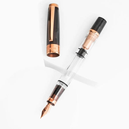 Twsbi Diamond 580 Smoke Rose Gold II fountain pen with an elegant rose gold finish and fine nib, showcasing a luxurious writing instrument.