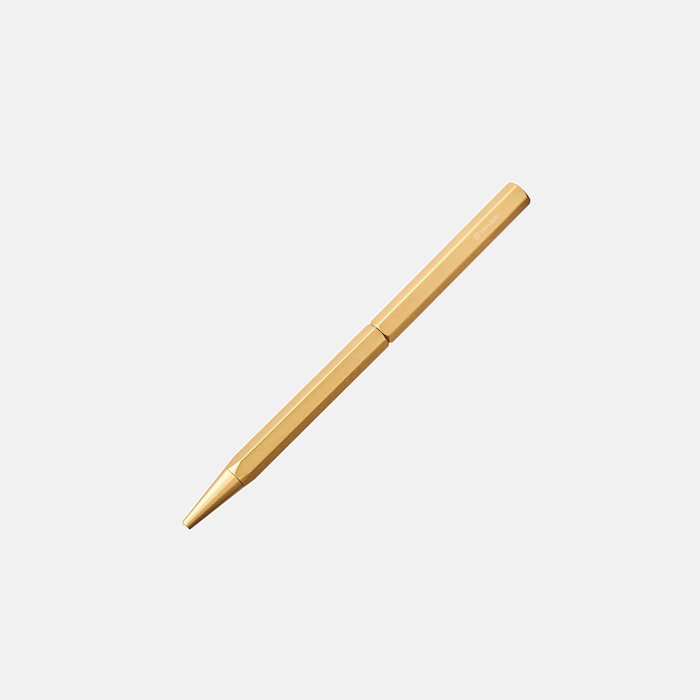 Y Studio Classic Revolve slim brass ballpoint pen with sleek design and smooth writing tip.